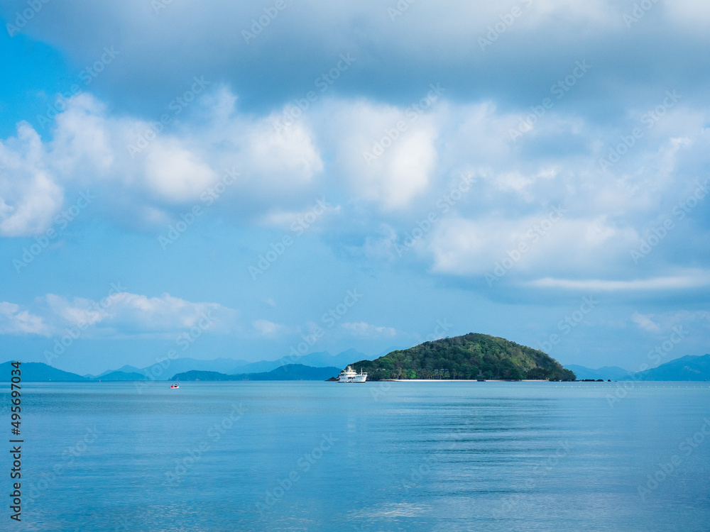 Scenic view of Koh Kham Island in peaceful bay against cloudy blue sky. Shot from Koh Mak Island, Trat, Thailand. Minimal background.
