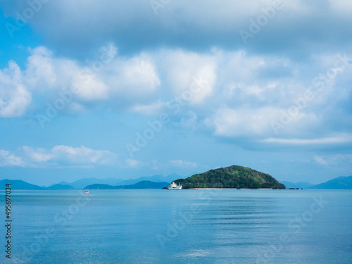 Scenic view of Koh Kham Island in peaceful bay against cloudy blue sky. Shot from Koh Mak Island, Trat, Thailand. Minimal background. © Chavakorn