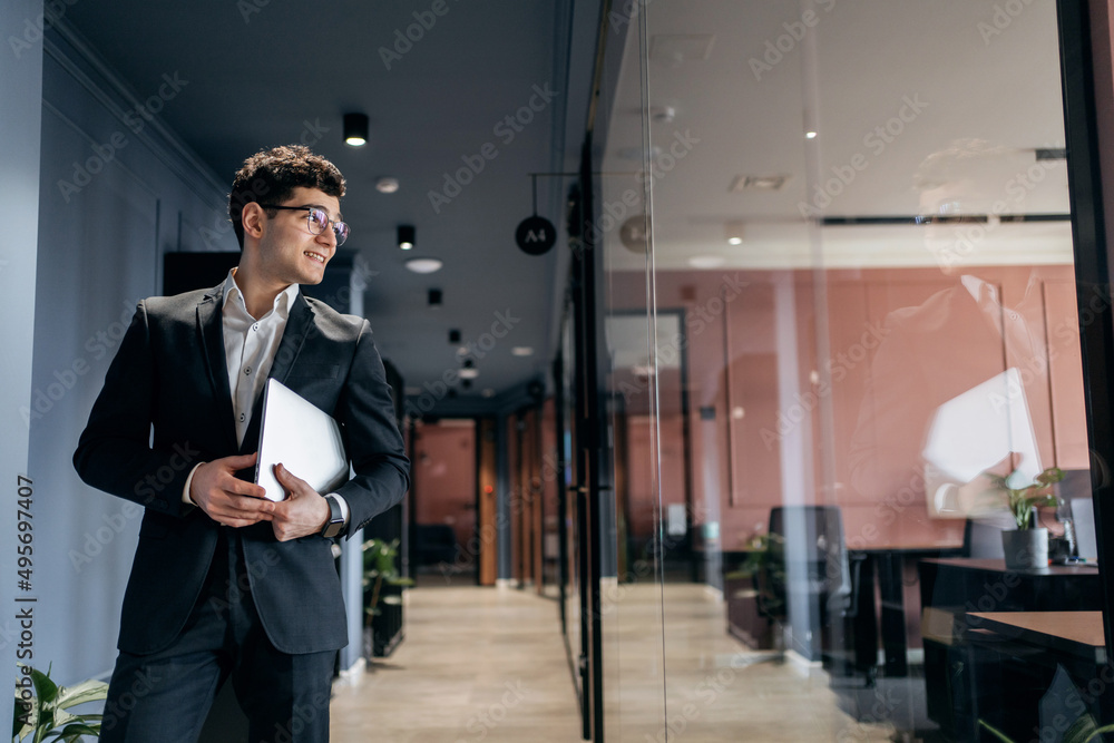 A manager in glasses and a business suit works in an office coworking space A manager in glasses and a business suit works in an office coworking space