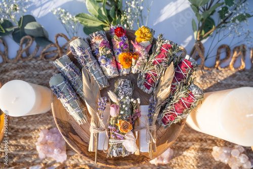 Top view of smudging sticks with dried flowers on a wooden tray