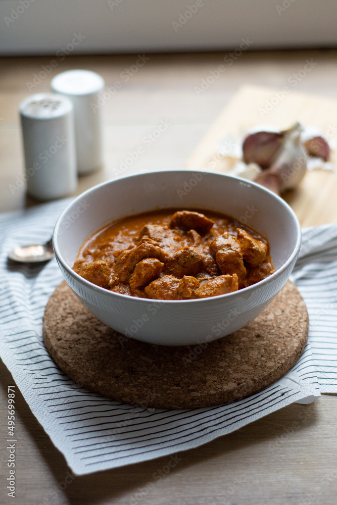 Chicken tikka masala dish bowl on a wooden table Chicken tikka masala dish bowl on a wooden table