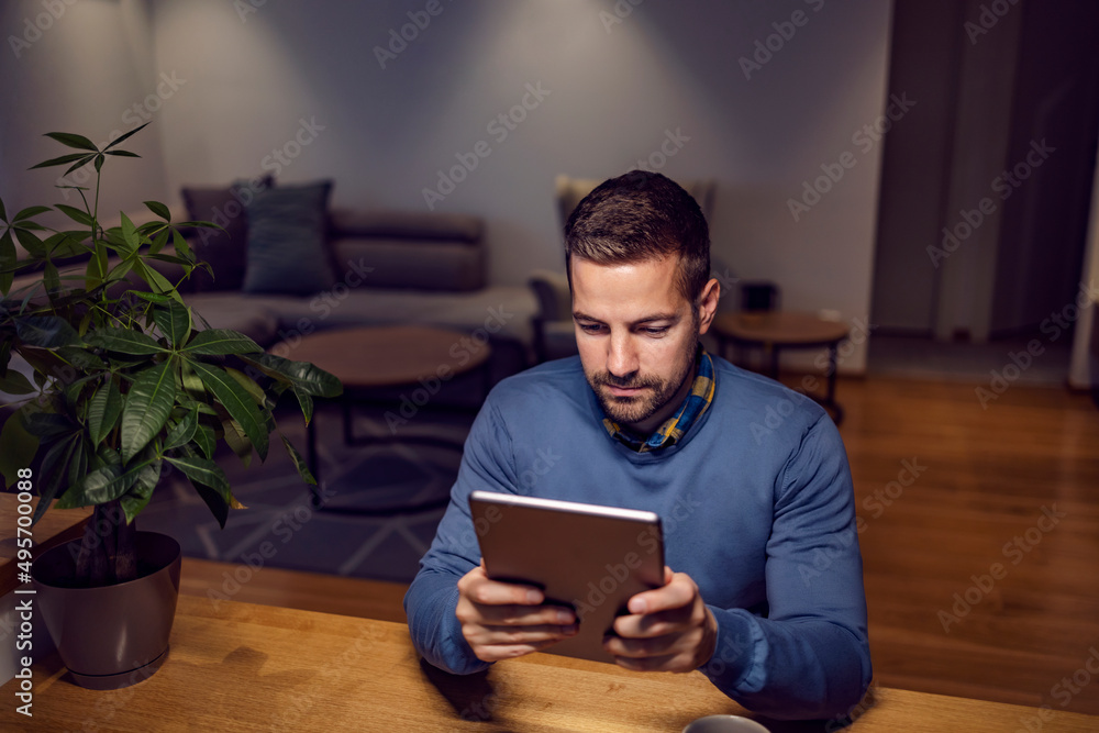 A man relaxing at home and reading an online book. A man relaxing at home and reading an online book.