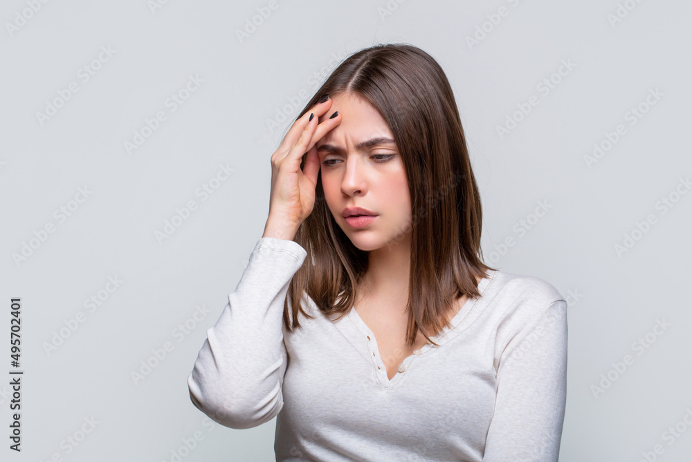 Woman suffering from headache desperate, stressed because pain and migraine. Woman with hard headache holding hands on head. Brunette woman touching her temples feeling stress, on gray background Woman suffering from headache desperate, stressed because pain and migraine. Woman with hard headache holding hands on head. Brunette woman touching her temples feeling stress, on gray background