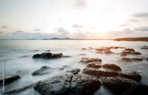 Sunset on the rocky shore. © xy