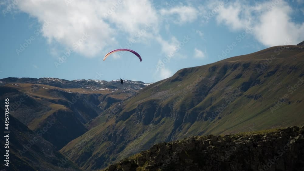 Parachutist flying high up next to the mountain peaks. Slow motion. Extreme sports activities concept. Parachutist flying high up next to the mountain peaks. Slow motion. Extreme sports activities concept.