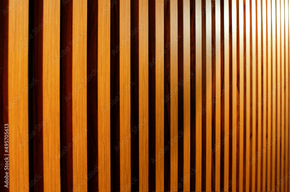 Wooden slats on the wall in a modern interior. Abstract background. Wooden wall. Side view. Wooden slats on the wall in a modern interior. Abstract background. Wooden wall. Side view.