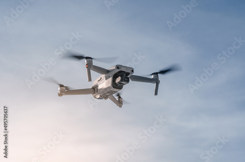 Drone flying in the air. Close. Blue sky background. New technologies.