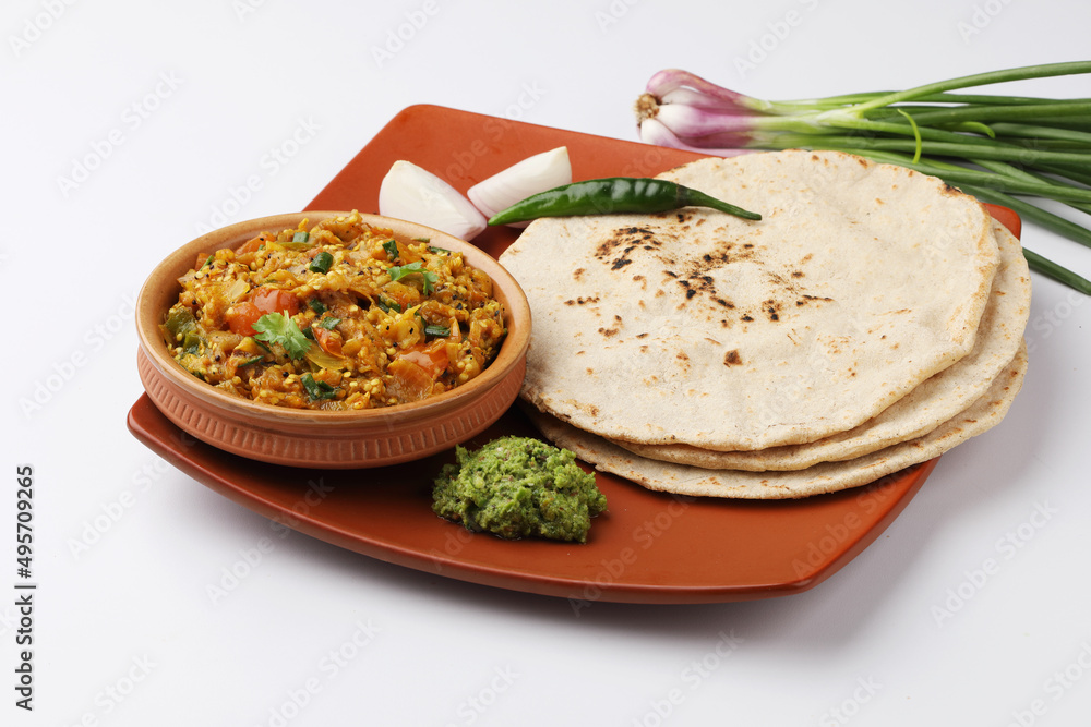indian village food roasted egg plant and bhakri or Indian flat bread Jowar Roti served with