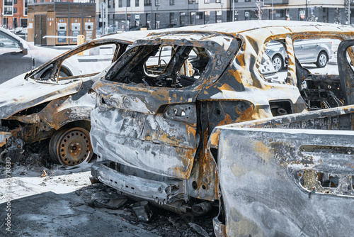 Close up photo of few burnt out cars. Not recoverable vehicles destroyed by fire. Rusty pile of metal. Insurance case.