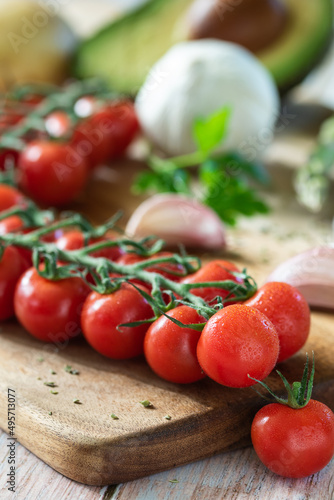 bunch of cherry tomatoes on a board with ingredients