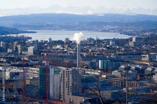 Aerial view over City of Zürich with Lake Zürich and Swiss Alps in the background on a blue and cloudy spring morning. Photo taken March 14th, 2022, Zurich, Switzerland.