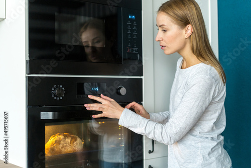 Woman baked fresh, homemade crusty bread in oven