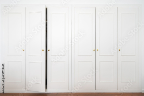 White wardrobe in american classic style with ajar door