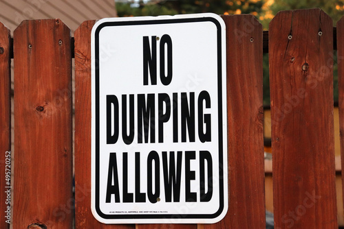 Closeup shot of a no dumping allowed sign on a wooden fence