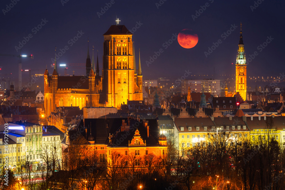 Cityscape of Gdansk with St. Mary Basilica and City Hall with the full moon, Poland.