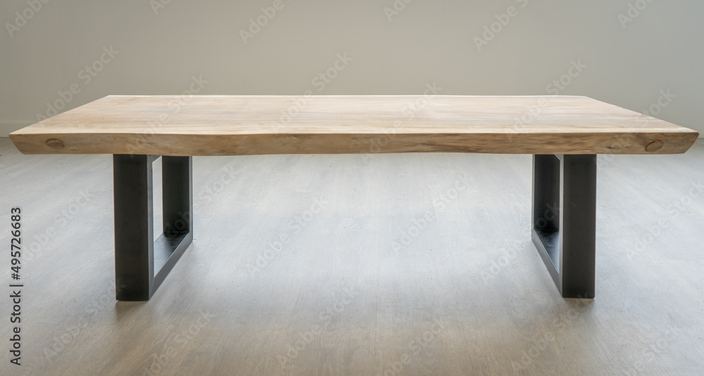 Obraz na płótnie Stół kawowy z egzotycznego drewna suar. Blat przytwierdzony jest do masywnych, metalowych nóg. Stół jest w stylu industrialnym. w salonie