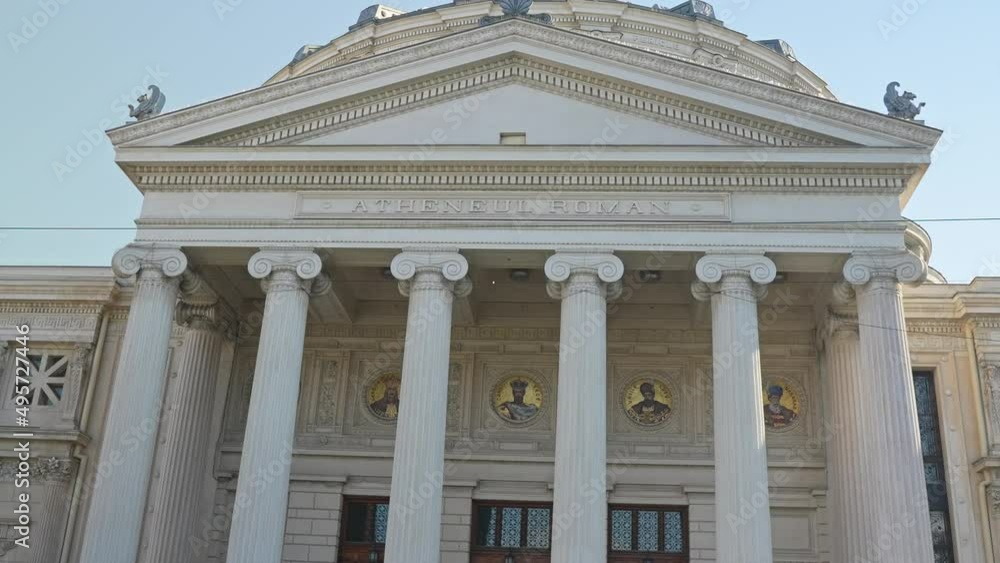 The romanian athenaeum on
victoriei street
in Bucharest
romania on a sunny spring day in 2022
old and beautiful building with green trees europe close up entrance