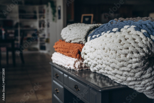 Canvas Print Closeup shot of soft custom made chunky blankets on the wooden small table in th