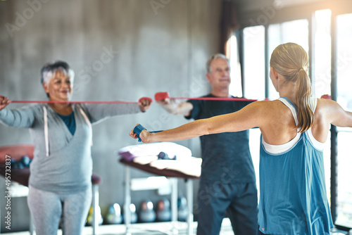 The senior years dont have to be the sedentary years. Shot of a senior man and woman using resistance bands with the help of a physical therapist.