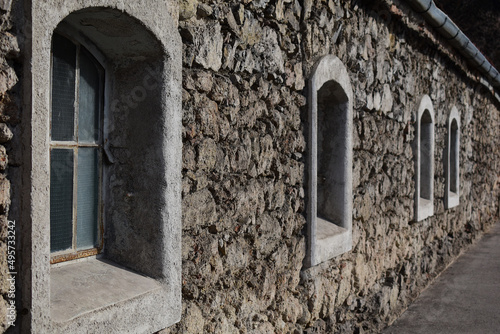 Aus Stein gemauertes, alten Haus mit steinumfassten Bogenfenstern photo