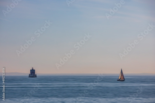 A boat passing New London Ledge Lighthouse in Groton, Connecticut on the Thames River at the mouth of New London harbor. Adamski effect