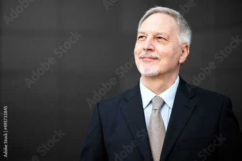 Mature business man portrait outdoor in a happy pensive expression © Minerva Studio