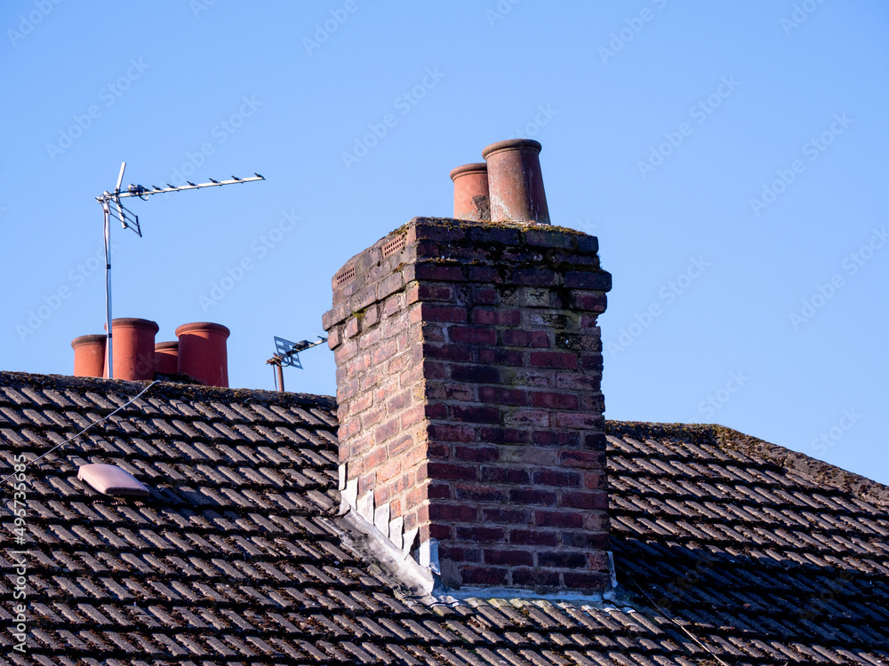 chimney and chimney pots on a tiled roofed house Photos | Adobe Stock