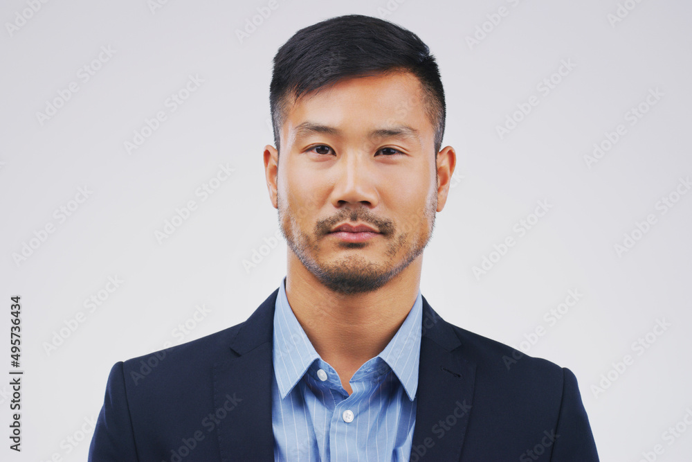 Hes a straight-faced businessman. Studio portrait of a handsome young businessman posing expressionless against a grey background. Hes a straight-faced businessman. Studio portrait of a handsome young businessman posing expressionless against a grey background.