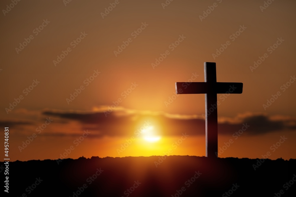 A christian cross at a scenic sunset or sunrise