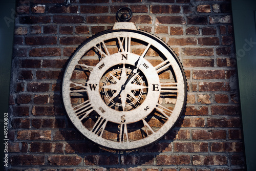 Closeup shot of a wooden clock on a concrete wall