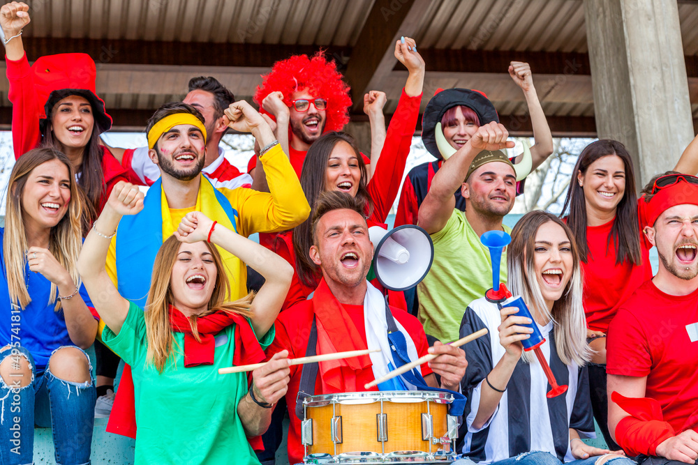 Fototapeta premium group of soccer fans watching a sports event in the stands of a stadium