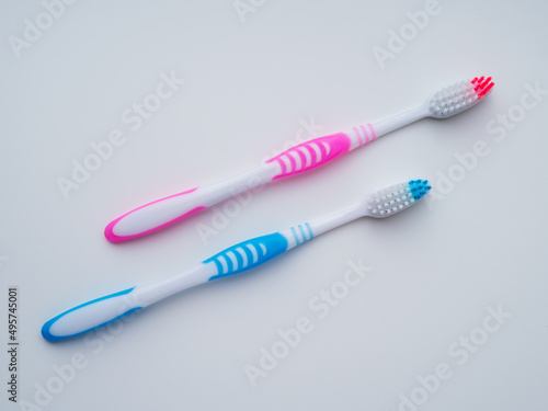 Two toothbrushes. Pink and blue. View from above.