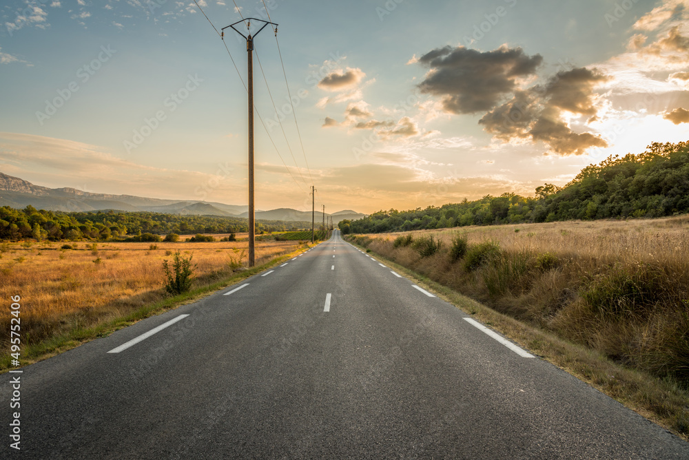 a long straight road at sunset