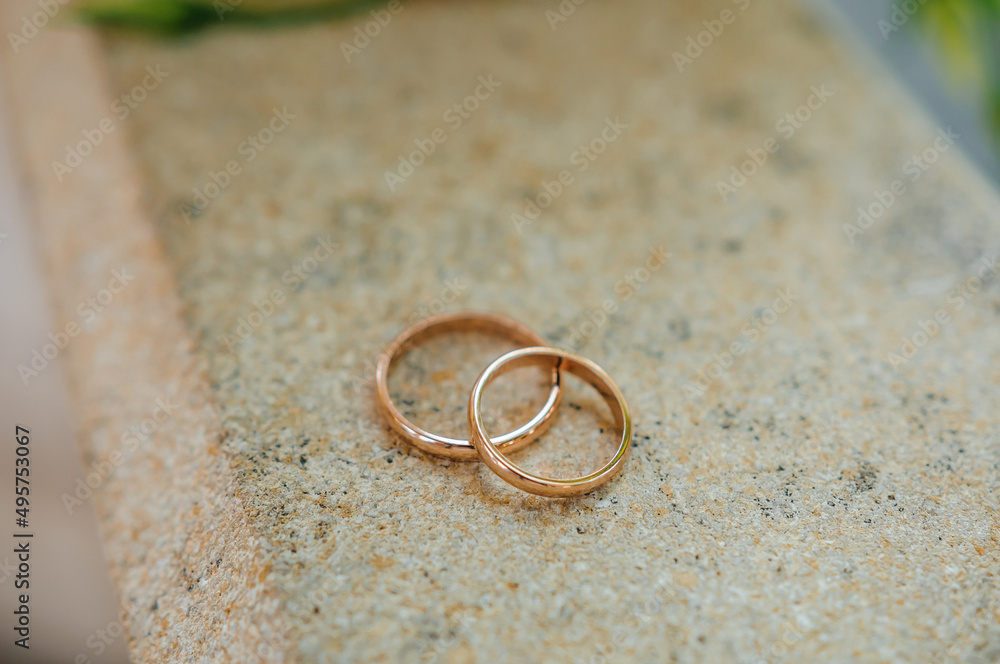 Pair of gold wedding rings on brown background Pair of gold wedding rings on brown background