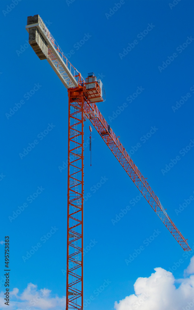 Tall construction tower crane against blue sky Tall construction tower crane against blue sky