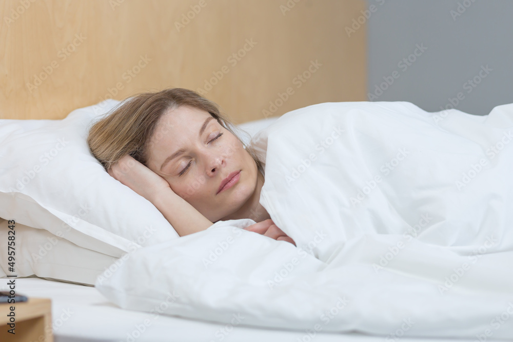 Woman sleeping at home under a blanket with eyes closed resting Woman sleeping at home under a blanket with eyes closed resting