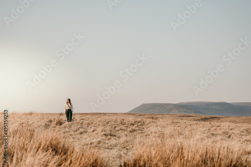 woman walking through field with mountain in background