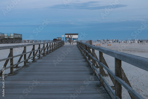 Wooden bordwalk to the famous stilt houses at St. Peter Ording beach.