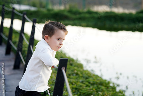 Photos Niño feliz alegré pensativo admirando y disfrutando viendo el lago el jardín en