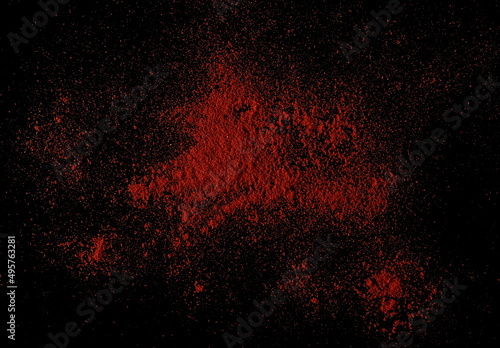Red paprika, pepper powder pile isolated on black, top view