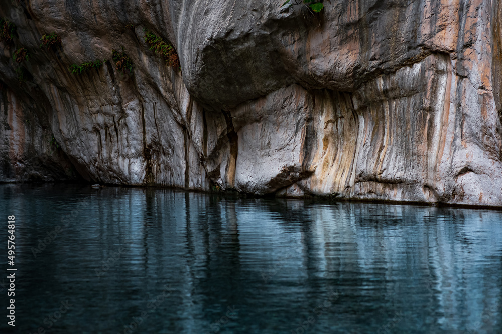 Fototapeta premium clean blue river with rocky banks at the bottom of a deep canyon