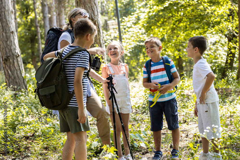 Group of children hiking in the forest with their teacher.They learn ...