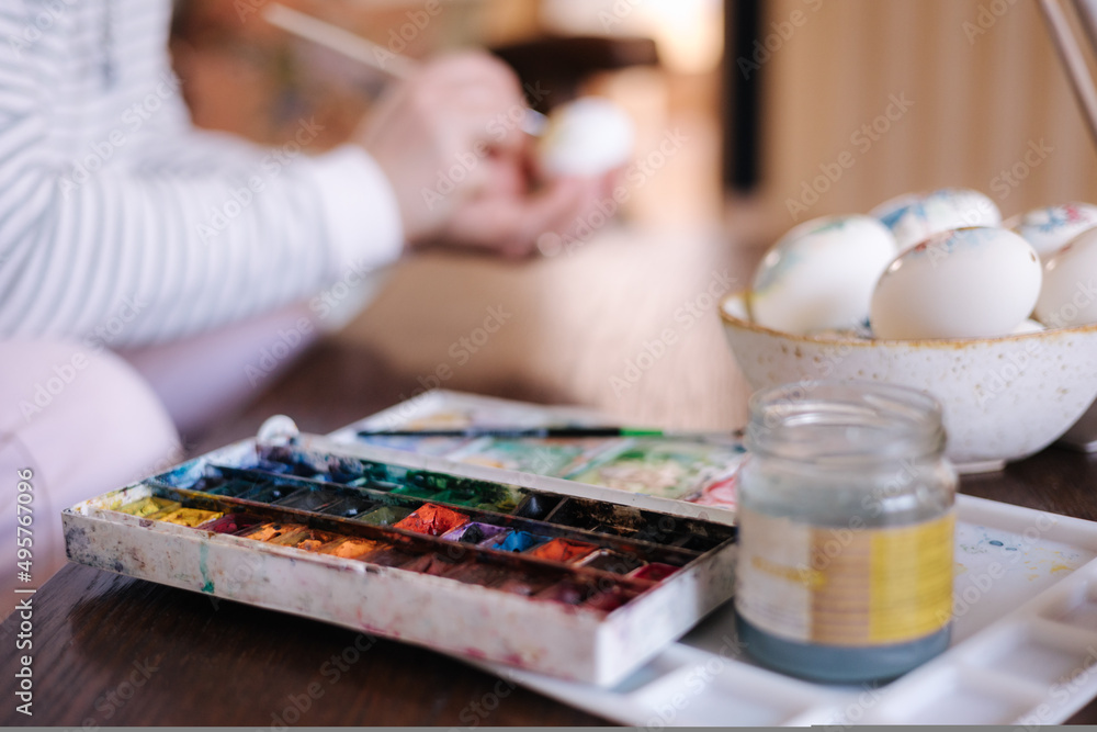 Process of woman paiting a water colors on fantasy chicken eggs. Female preparing for Easter egg festival Process of woman paiting a water colors on fantasy chicken eggs. Female preparing for Easter egg festival