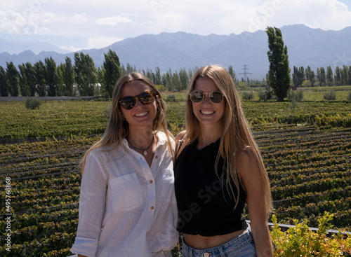 Wine route. Two young woman wearing sunglasses with the vineyards behind. 