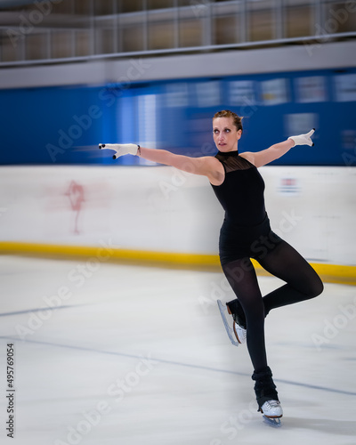 Woman doing a nice figure in ice skating with motion blur effect