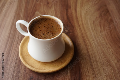 a cup of foamy turkish coffee on the wooden table © Caltili