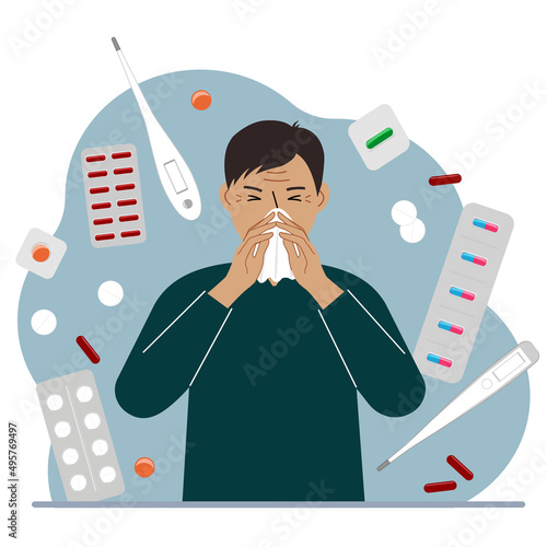 A man covers his nose with his hands with a handkerchief. The concept of a cold person, seasonal allergies. Lots of medicines and thermometers.