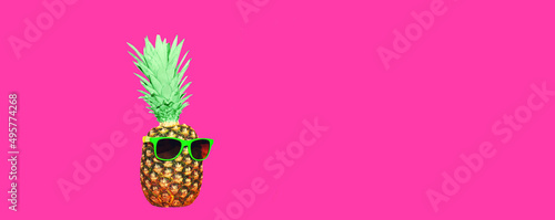Pineapple with pink sunglasses on pink background, colorful ananas