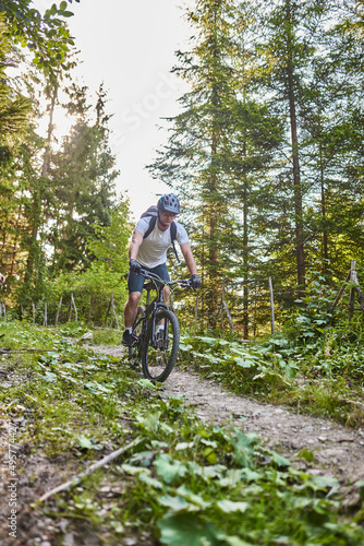Cyclist Riding the Bike on the Trail in the Forest. Man cycling on enduro trail track. Sport fitness motivation and inspiration. Extreme Sport Concept. Selective focus © Minet