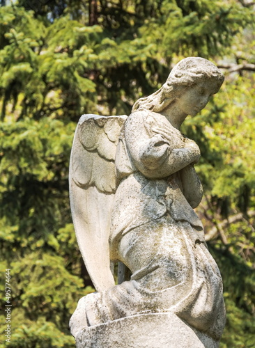 Ancient stone statue of a sad  grieving angel